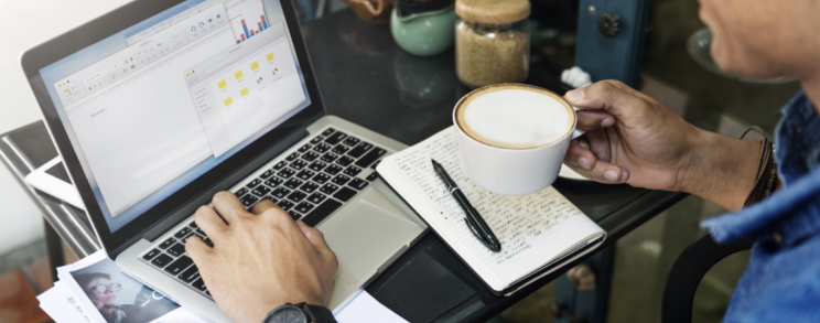 Man op laptop met koffie