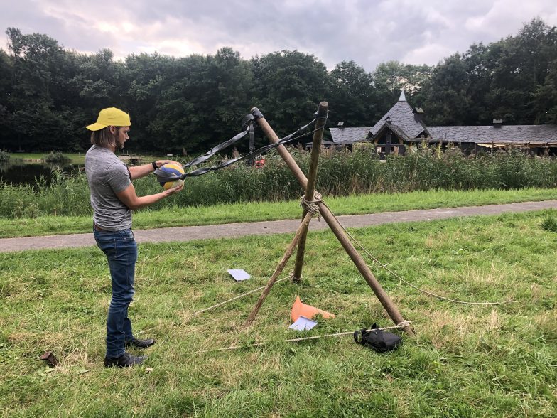Man gele pet bezig met katapult